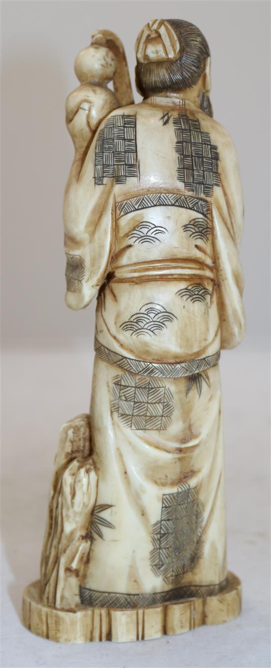 A Japanese walrus ivory figure of a man pouring water from a gourd, early 20th century, height 21cm